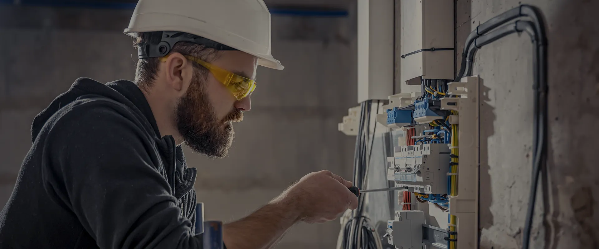 Técnico especializado instalando un cuadro eléctrico y realizando mantenimiento de fontanería.